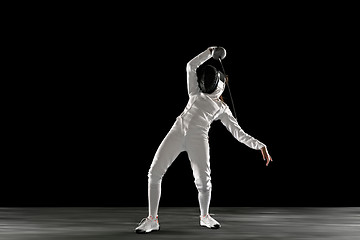 Image showing Teen girl in fencing costume with sword in hand isolated on black background