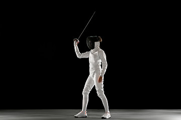 Image showing Teen girl in fencing costume with sword in hand isolated on black background