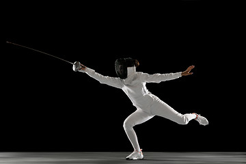 Image showing Teen girl in fencing costume with sword in hand isolated on black background