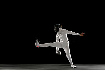 Image showing Teen girl in fencing costume with sword in hand isolated on black background