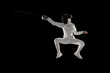 Image showing Teen girl in fencing costume with sword in hand isolated on black background