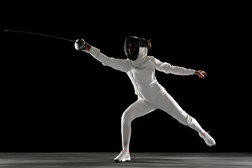 Image showing Teen girl in fencing costume with sword in hand isolated on black background