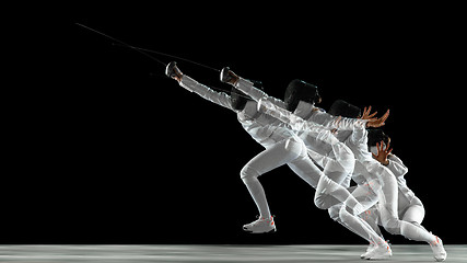 Image showing Teen girl in fencing costume with sword in hand isolated on black background