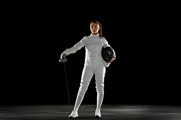 Image showing Teen girl in fencing costume with sword in hand isolated on black background