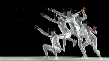 Image showing Teen girl in fencing costume with sword in hand isolated on black background