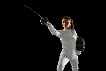 Image showing Teen girl in fencing costume with sword in hand isolated on black background