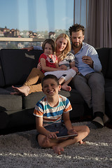 Image showing happy young couple spending time with kids at home