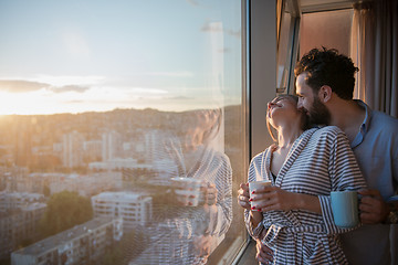 Image showing young couple enjoying evening coffee by the window