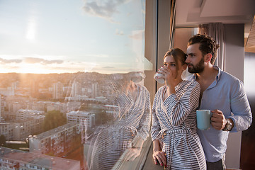 Image showing young couple enjoying evening coffee by the window