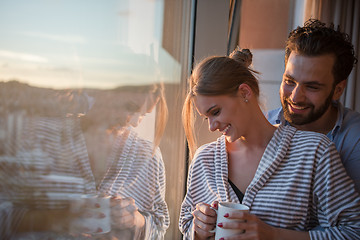 Image showing young couple enjoying evening coffee by the window