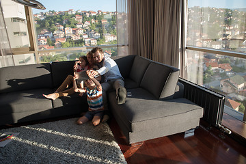 Image showing happy young couple spending time with kids at home