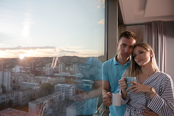 Image showing young couple enjoying evening coffee by the window