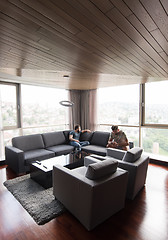 Image showing two young men using a mobile phones  at home