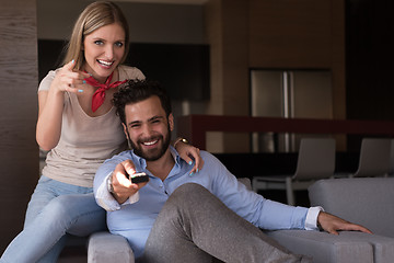 Image showing Young couple on the sofa watching television