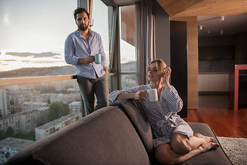 Image showing young couple enjoying evening coffee by the window