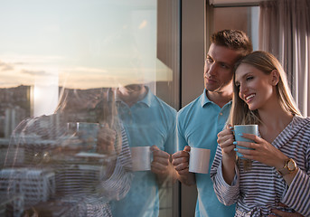 Image showing young couple enjoying evening coffee by the window