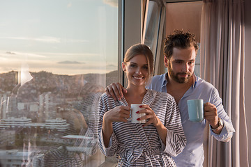 Image showing young couple enjoying evening coffee by the window