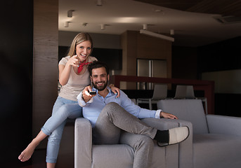 Image showing Young couple on the sofa watching television