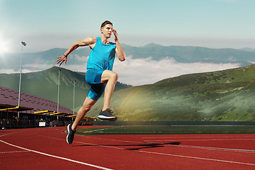 Image showing man running in the track. Fit male fitness runner jogging in stadium