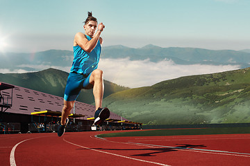 Image showing man running in the track. Fit male fitness runner jogging in stadium