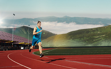 Image showing man running in the track. Fit male fitness runner jogging in stadium