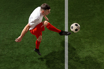 Image showing Football player tackling ball over green grass background