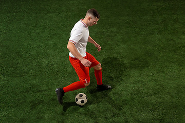 Image showing Football player tackling ball over green grass background