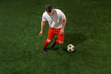 Image showing Football player tackling ball over green grass background