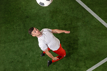 Image showing Football player tackling ball over green grass background