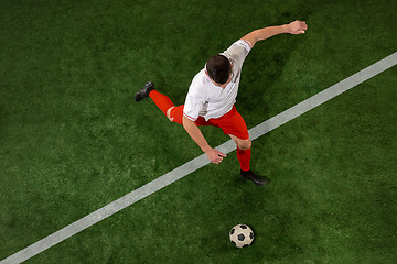 Image showing Football player tackling ball over green grass background