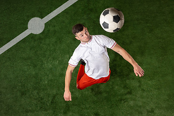 Image showing Football player tackling ball over green grass background