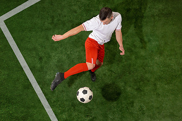 Image showing Football player tackling ball over green grass background