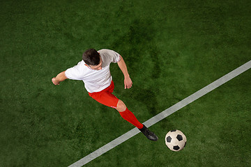 Image showing Football player tackling ball over green grass background