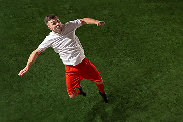 Image showing Football player tackling ball over green grass background