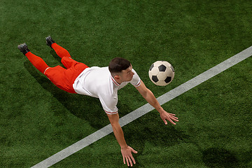 Image showing Football player tackling ball over green grass background