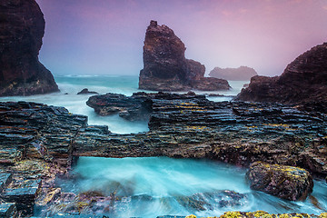 Image showing Natural bridge over tidal waters along craggy coastline