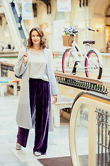 Image showing woman in a light knitted coat and purple trousers