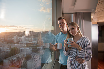 Image showing young couple enjoying evening coffee by the window