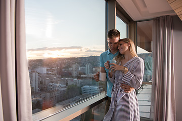 Image showing young couple enjoying evening coffee by the window