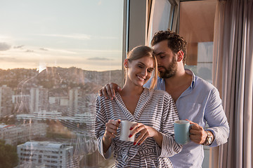 Image showing young couple enjoying evening coffee by the window