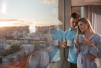 Image showing young couple enjoying evening coffee by the window