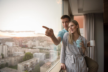 Image showing young couple enjoying evening coffee by the window