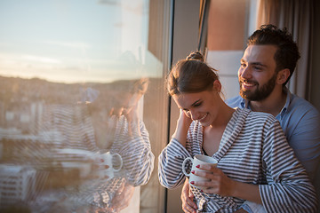 Image showing young couple enjoying evening coffee by the window