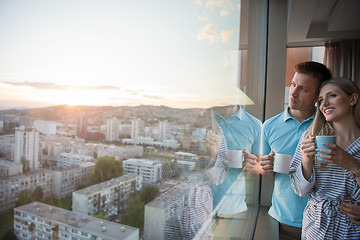 Image showing young couple enjoying evening coffee by the window