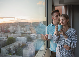 Image showing young couple enjoying evening coffee by the window