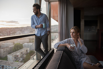 Image showing young couple enjoying evening coffee by the window