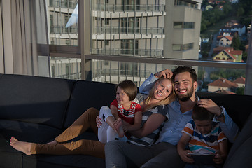 Image showing happy young couple spending time with kids at home