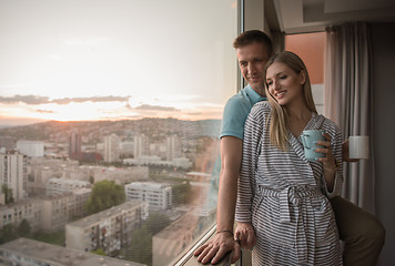 Image showing young couple enjoying evening coffee by the window