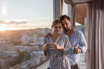 Image showing young couple enjoying evening coffee by the window