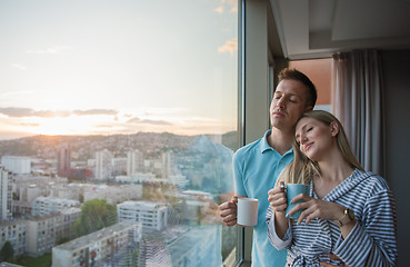 Image showing young couple enjoying evening coffee by the window